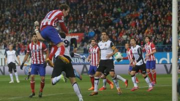 El uruguayo  Diego Godin (arriba) marca el gol del triunfo del Atlético de Madrid, que se impuso 1-0 al Valencia en los octavos de final de la Copa del Rey.