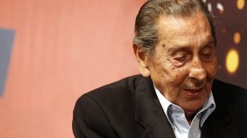 El exfutbolista uruguayo Alcides Ghiggia toca el trofeo del Mundial Brasil 2014
