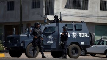 La Policía federal patrulla la entrada de Apatzingán. Los soldados mexicanos y policías federales mantienen un duro enfrentamiento con las autodefensas y los narcotraficantes en Michoacán.