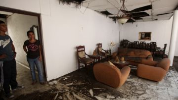 Dos habitantes observan  los daños causados en una vivienda por la explosión de una motocicleta bomba en el municipio de Pradera, Valle del Cauca.