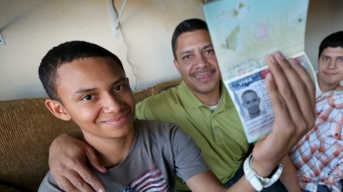 Brian con su padre y hermanos, Josué y  Angel Omar, rebosantes de alegría con los  papeles a mano.