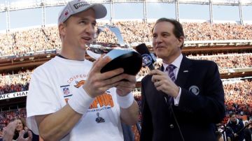 El  quarterback Peyton Manning (izq.) recibe el trofeo  de campeones de la Liga Americana de la NFL, tras la victoria de los Broncos de Denver por pizarra de 26-16 sobre los Patriots de Nueva Inglaterra.