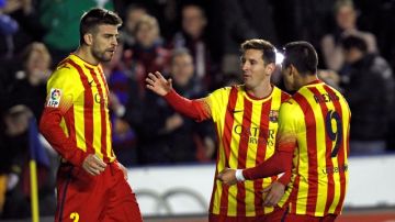 Gerard Pique (izq.) es felicitado por Alexis Sanchez (der.) y  Lionel Messi, tras marcar el empate ante Levante.