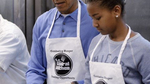 El presidente Barack Obama (2d), y su hija Sasha (d) participan en un proyecto de servicios comunitarios en Washington DC.