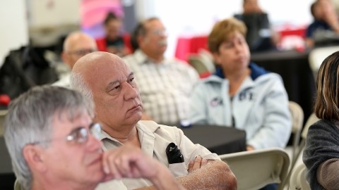 Personas interesadas en obtener un nuevo seguro médico escuchan sobre las diferentes opciones, durante unl foro comunitario.