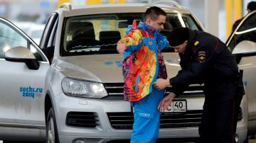 Policías rusos revisan a un conductor y su vehículo a la entrada de la Villa Olímpica en Sochi.
