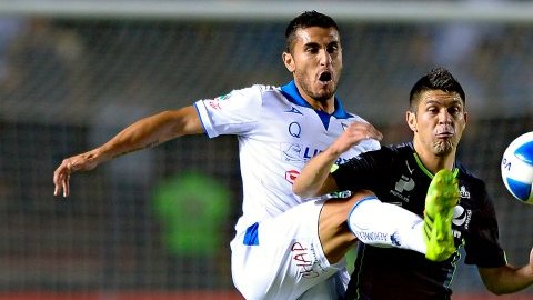 Oribe Peralta, delantero del Santos Laguna, intenta proteger el esférico