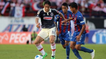 Los jugadores del Atlante Michael Arroyo y Salustino Candia marcan a Denigris, de Guadalajara.
