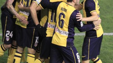 Los jugadores del Atlético de Madrid abrazan a  David Villa (c), quien marcó el primer tanto en la  victoria de 4-2 ante  el Rayo Vallecano.
