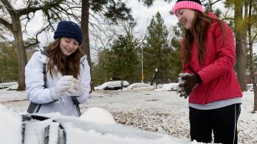 Las estudiantes Tara Ramsey (izq.) y Makenzie Dickins juegan con la nieve en Nacogdoches, Texas.