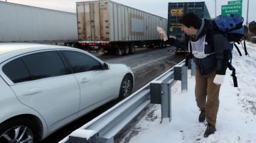 Un voluntario ofrece alimentos y agua a las personas que llevan horas atrapadas en el tráfico en las autopistas de Atlanta tras la nevada caída el martes.