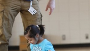 La estudiante Shailin Montes, 4 años (a la derecha), en la patineta  con ayuda de la terapeuta ocupacional Amy Alpert.