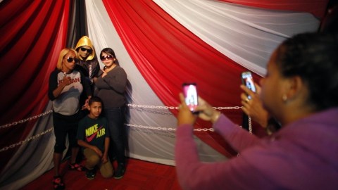 La madre, la viuda y el hijo de Christopher "Perrito" Rivera posan junto al cuerpo del fenecido boxeador.