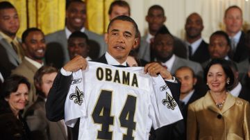 Obama en una foto de archivo posa con una camiseta de los New Orleans Saints que recibió de manos del quarterback Drew Brees.