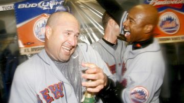 Manny Acta (i), cuando era coach de los Mets, celebra con Michael Tucker (d) la victoria de su club sobre los Dodgers en Los Angeles, en los playoffs de 2006.