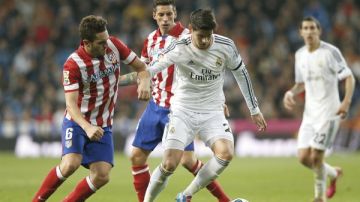 El centrocampista del Real Madrid Morata (d) lucha un balón con el centrocampista del Atlético de Madrid Koke Resurrección