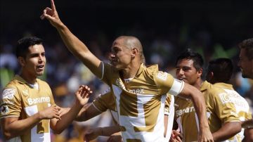 El jugador de Pumas Darío Verón (c) celebra una anotación  en el Estadio Olímpico Universitario, en la Ciudad de México.