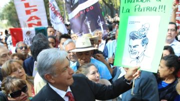 El líder izquierdista Andrés Manuel López Obrador (frente) sostiene un cartel  tras la presentación de una demanda contra el presidente de México Enrique Peña Nieto en las oficinas de  la Procuraduría General de la República (PGR, Fiscalía).