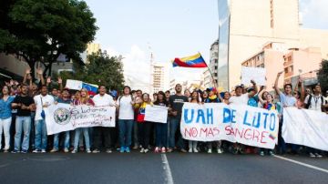 Estudiantes opositores al Gobierno venezolano durante una manifestación estudiantil en Chacao, Caracas. Venezuela se mantuvo hoy en una tensa calma después de los hechos de violencia del miércoles.
