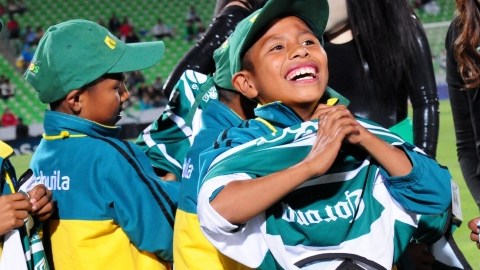 Un niño triqui sonríe al ponerse una camiseta del Sntos, equipo que  ayer homenajeó a los pequeños campeones mundiales.