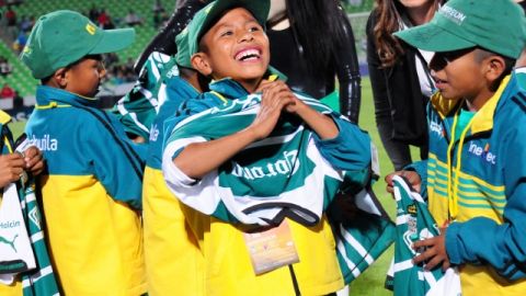 Un niño triqui sonríe al ponerse una camiseta del Sntos, equipo que ayer homenajeó a los pequeños campeones mundiales.