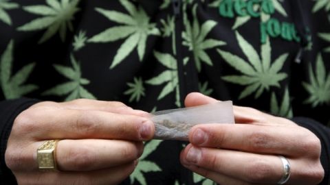 En esta foto se observa a un joven, con una camisa alusiva a la planta, liando un cigarillo de esa yerba dentro del marco de la Marcha Mundial de la Marihuana.