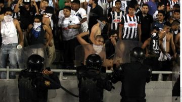 Policías tratan de meter al orden a varios seguidores del Monterrey en el Estadio Tecnológico.