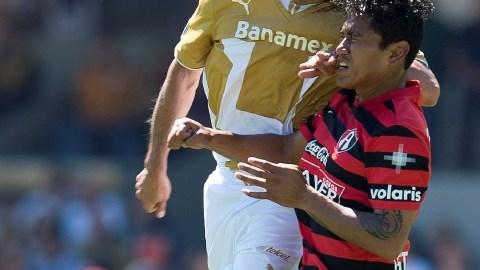 Diego Lagos, de Pumas,  y Jorge Gastelum  de Atlas (der.) pelean  por alto el balón durante el juego de ayer en Ciudad Universitaria.