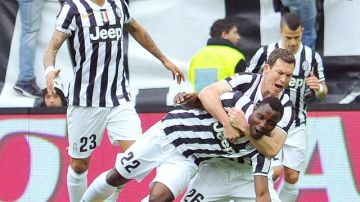 Kwadwo Asamoah es tomado del cuello por uno de sus compañeros del Juventus tras anotar  ayer sobre el Verona.