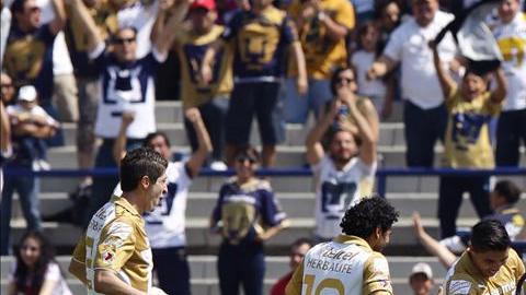 Jugadores de Pumas celebran una anotación en el Estadio Olímpico Universitario.
