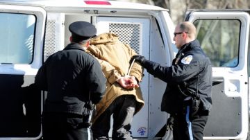 Un activista es conducido por policías, tras ser arrestado en un acto en el que   recordaron a   los cerca de dos millones de deportados bajo el mandato de  Obama.