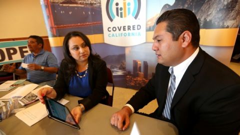 Erick Verduzco Vega (der), dueño de un bar en Long Beach analiza sus opciones de cobertura para empleados.