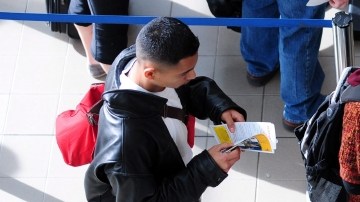 Un agente  de TSA revisa los documentos de pasajeros en el aeropuerto internacional de Los Ángeles.