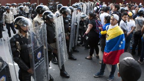 Miembros de la policía venezolana tratan de frenar una marcha de los estudiantes ayer en las calles de Caracas.
