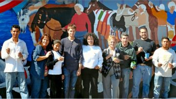 El joven artista Emet Sosna (camisa azul) y los trabajadores de Belmont Park junto al mural que crearon.