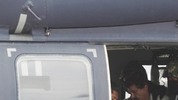 Joaquín 'El Chapo' Guzmán es escoltado en un helicóptero de la Armada de México con las manos esposadas.