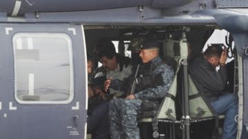 Joaquín 'El Chapo' Guzmán es escoltado en un helicóptero de la Armada de México con las manos esposadas.