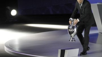 El exportero francés Fabien Barthez lleva el trofeo de la Eurocopa antes del sorteo clasificatorio.