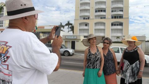 Los paseantes se toman fotografías afuera del condominio donde fue aprehendido "El Chapo".