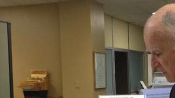 Jerry Brown firmando los papeles para postularse nuevamente como candidato a gobernador de California en las próximas elecciones.