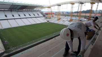 Dos obreros trabajan en las obras del estadio Arena Corinthians en la ciudad de Sao Paulo.