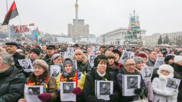 Ciudadanos ucranianos sostienen fotos de personas que murieron durante las protestas en Kiev, Ucrania.