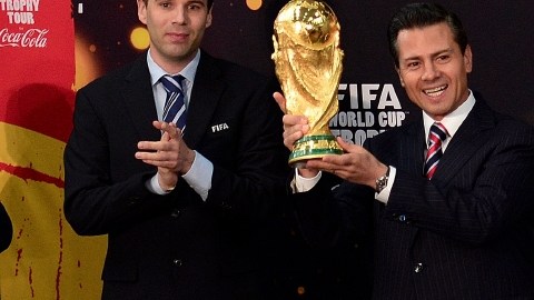 Enrique Peña sostiene el trofeo FIFA, que sigue viajando.