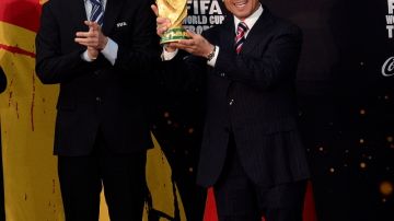 Enrique Peña sostiene el trofeo FIFA, que sigue viajando.