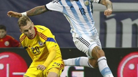 Marcos Rojo  de Argentina (der.), se quita la marca del  rumano Alexandru Maxim  durante el juego de ayer.