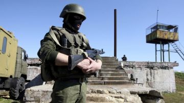 Hombres armados, con uniformes de soldados, vigilan los terrenos de una unidad militar ucraniana en Sebastopol, en Crimea.