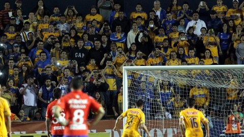 'Juninho'  (izq.) vence a Jesús Corona para abrir la cuenta de goles.