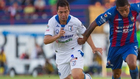 Michael Arroyo  (der.) adelanta el balón ante la marca de Gerardo Espinoza, de Gallos Blancos.