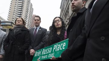 La madre y el padre de Ariel Russo sostienen el letrero que sería colocado más tarde en el lugar. A la extrema izquierda, la presidenta del Concejo de NYC, Melissa Mark-Viverito.