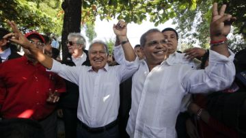 El candidato  del Frente Farabundo Martí para la Liberación Nacional (FMLN), Salvador Sánchez Cerén (i), saluda junto a su fórmula vicepresidencial Oscar Ortiz.